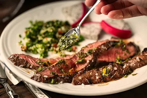 Sliced churrasco steak with chimichurri