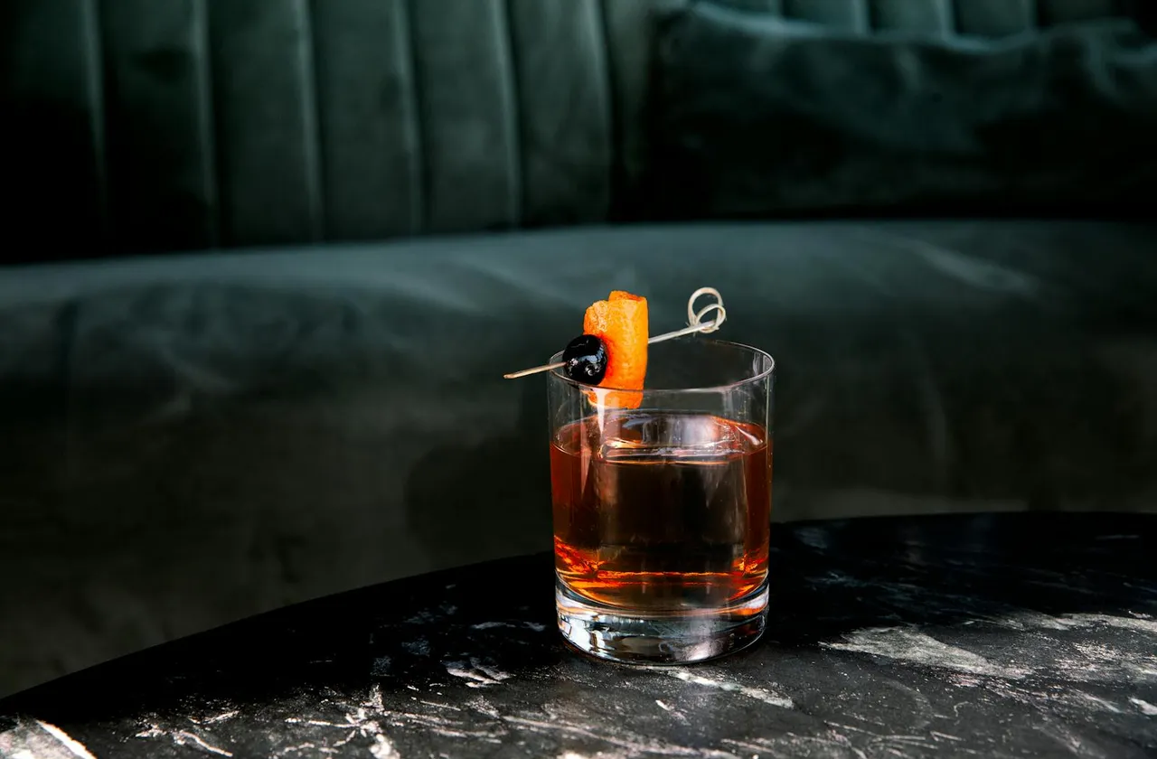 An old fashioned on a marble table in the lounge at The Nest